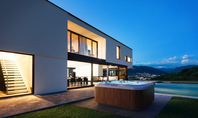 A large outdoor hot tub sitting in the middle of a yard.