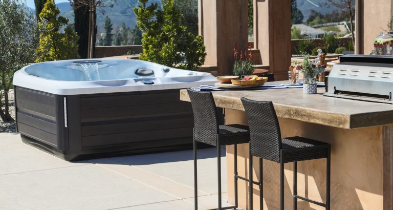 A patio with an outdoor bar and hot tub.