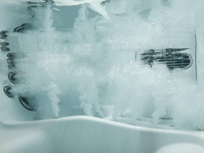 A view of the outside of a bathtub with water coming out.