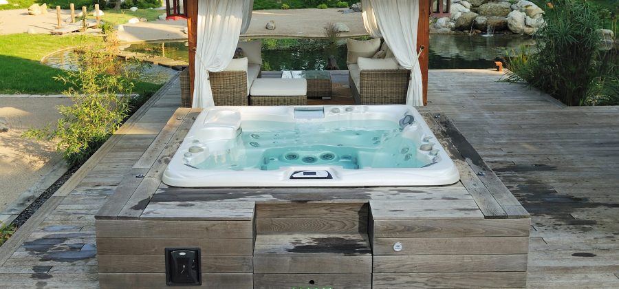 A hot tub sitting on top of a wooden deck.