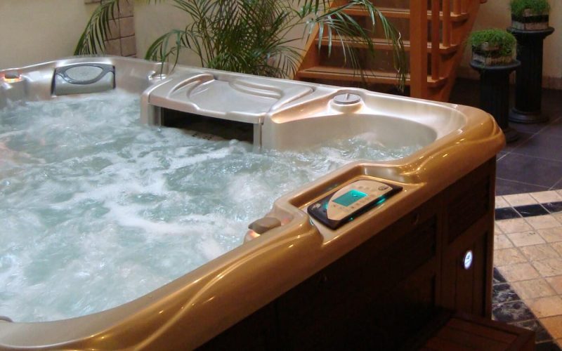 A hot tub with wooden trim and a remote control.