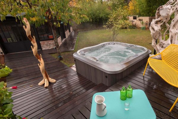A hot tub sitting on top of a wooden deck.
