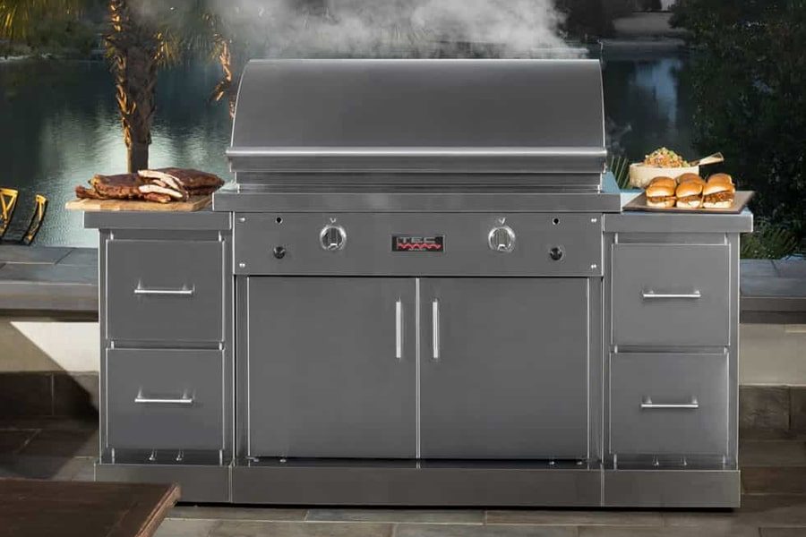 A stainless steel grill with smoke coming out of the top.